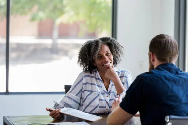 Photo of Mature businesswoman talks withe male colleague