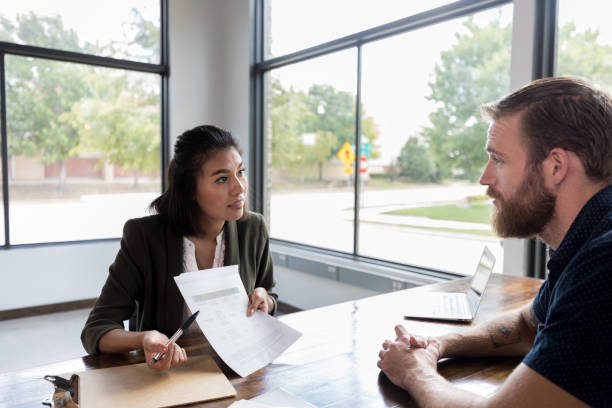 istock Loan officer reviews customer's loan application 1181008297