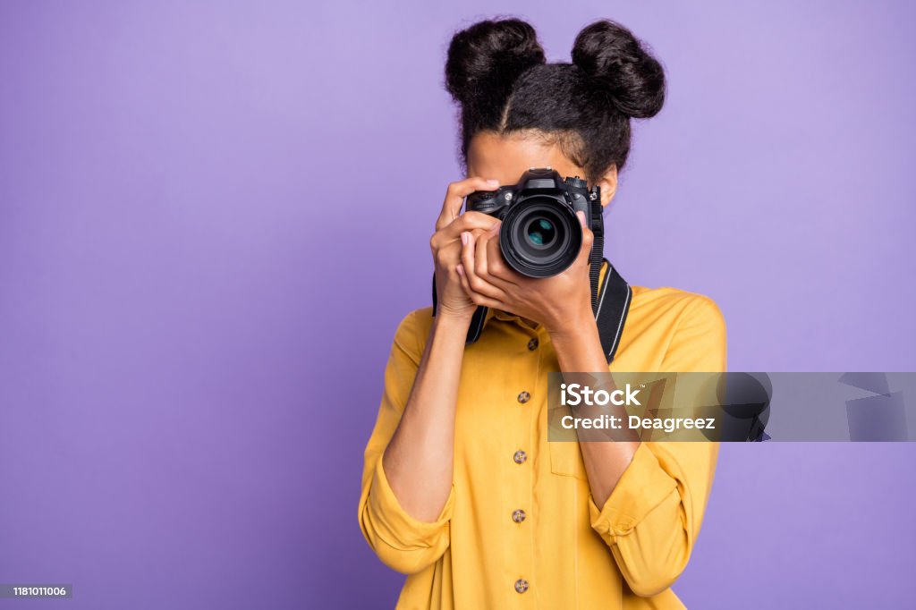 海外観光の写真を手に持つ驚くべき暗い肌の女性の写真は、黄色のシャツのズボンを着用紫色の背景を着用 - 写真家のロイヤリティフリーストックフォト