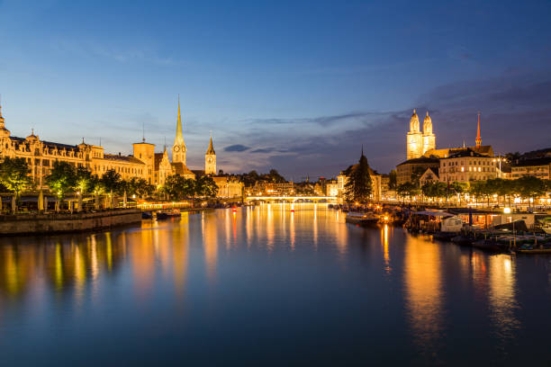 skyline del centro di zurigo sul lago di zurigo di notte, svizzera - grossmunster cathedral foto e immagini stock