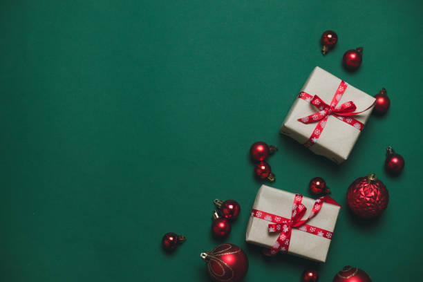 istock Creative composition with gifts or presents boxes with red bows, red balls on green background top view. Flat lay composition for birthday, christmas or wedding. 1181013328