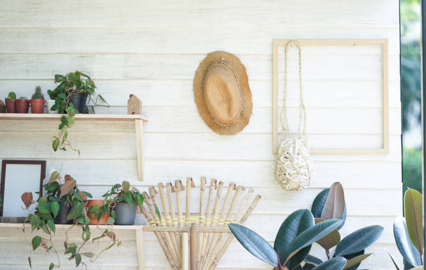 Gardening tools storage including straw hat, broomstick, succulent plants and flower pots. stock photo
