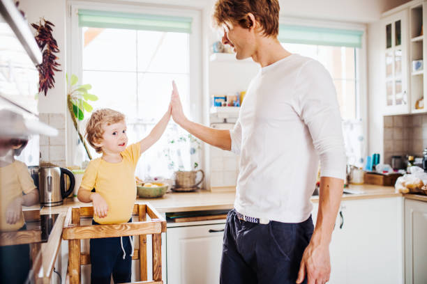 istock A young father with a toddler son in a kitchen at home, giving high five. 1181017003