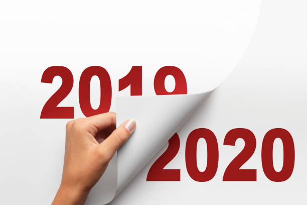 istock Woman's Hand Turning The Page From 2019 To 2020 1181017923