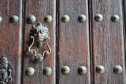Up close of a door knocker on a wood door