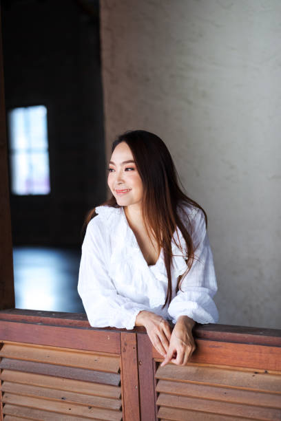 istock Thai woman standing at window 1181018731
