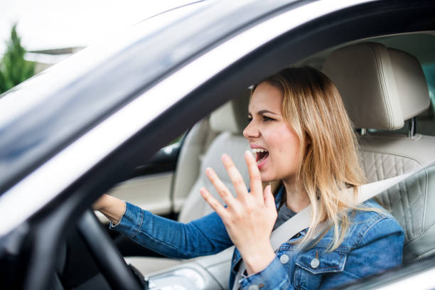 istock Angry young woman driver sitting in car, shouting. 1181019454