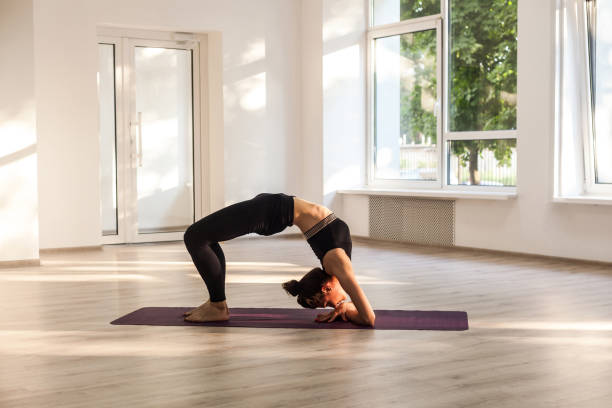 joven adulta atractiva mujer yogui practicando yoga, estiramiento en el ejercicio de puente de codo, dvi pada viparita dandasana pose, hacer ejercicio, usar ropa deportiva negra - dvi fotografías e imágenes de stock