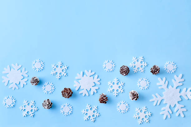 istock Flat lay christmas border with snowflakes and cones on a blue background 1181020364