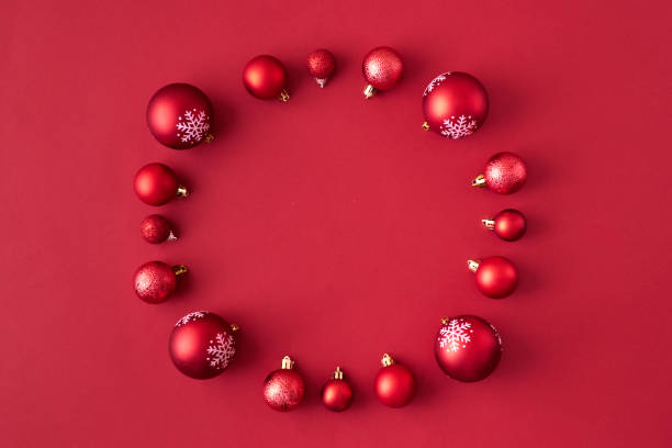 istock Flat lay frame with red christmas balls on a red background 1181020449