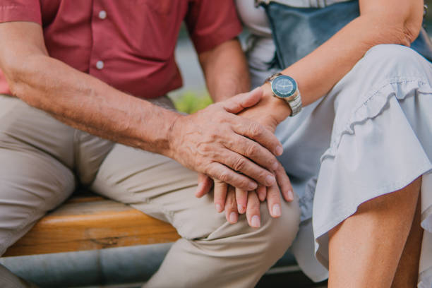 istock Old couple holding and showing their hands 1181022404