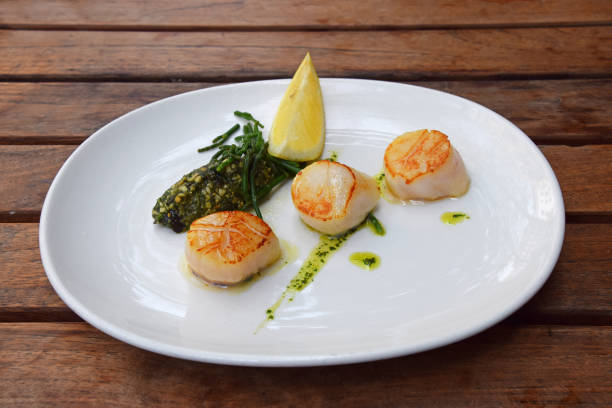 istock Portion of grilled scallops on plate on table 1181023598