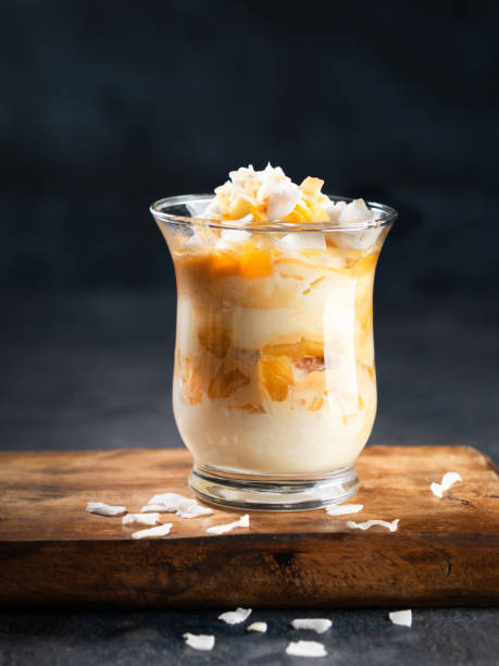 istock Pineapple, peach, Coconut Trifle dessert mouse in a glass on a dark background with copy space. Vegan recipe dessert concept. Selective focus. 1181026873
