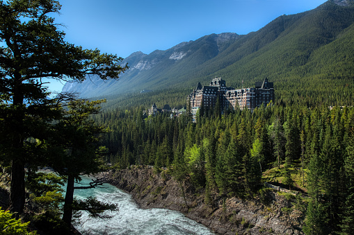 Stunning view of the iconic Fairmont Banff Springs Hotel situated near the bottom of Sulphur Mountain with Bow Falls below, Banff National Park, Alberta, Canada