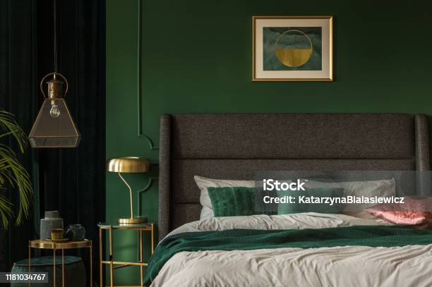 Stylish Emerald Green And Golden Poster Above Comfortable King Size Bed With Headboard And Pillows In Dark Green Bedroom Stock Photo - Download Image Now