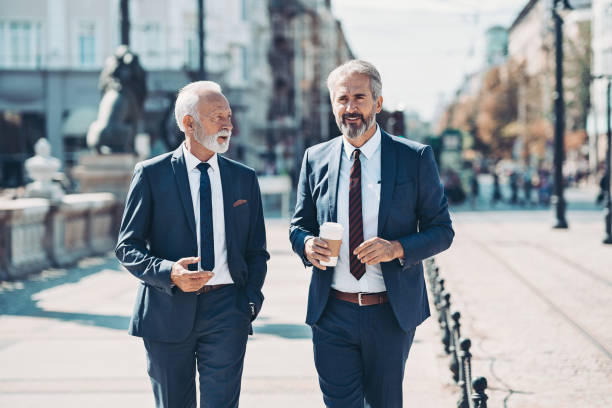 istock Two businessmen walking and talking outdoors 1181035361