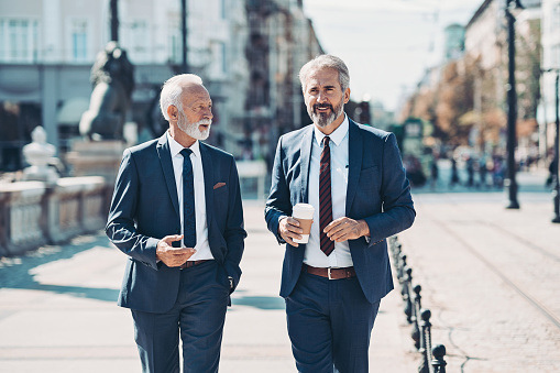 Mature businessmen walking together outdoors in the city