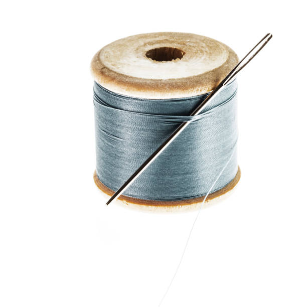 istock Isolated old wooden thread spool with needle. 1181035879