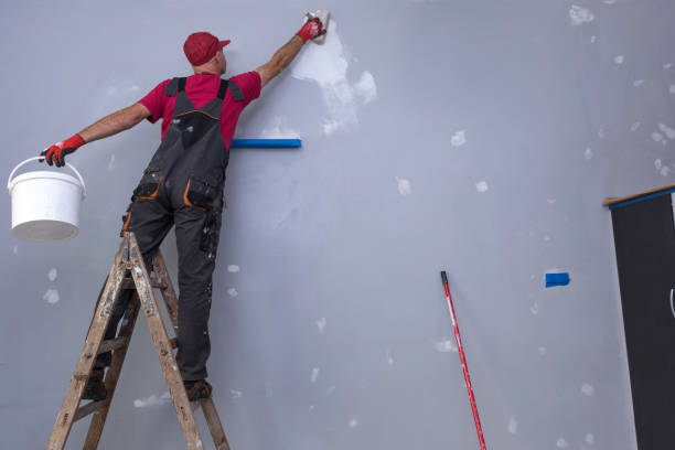 istock Home Painter, painter man at work, with wooden ladder and blank wall 1181037168