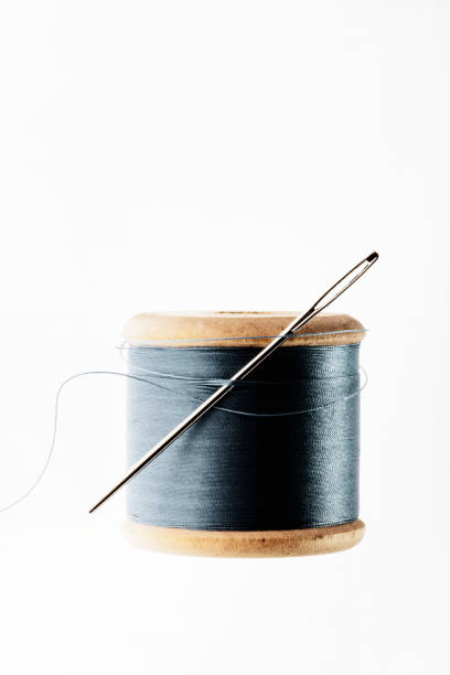 istock Isolated old wooden thread spool with needle. 1181037173