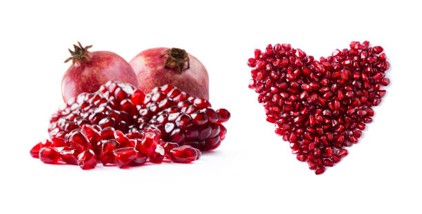 istock Pomegranate isolated on white background. Sweet and juicy garnet with copy space for text. Garnets isolated on white. Heart shape pomegranate seeds and two garnets fruit, isolated on white background. 1181037636
