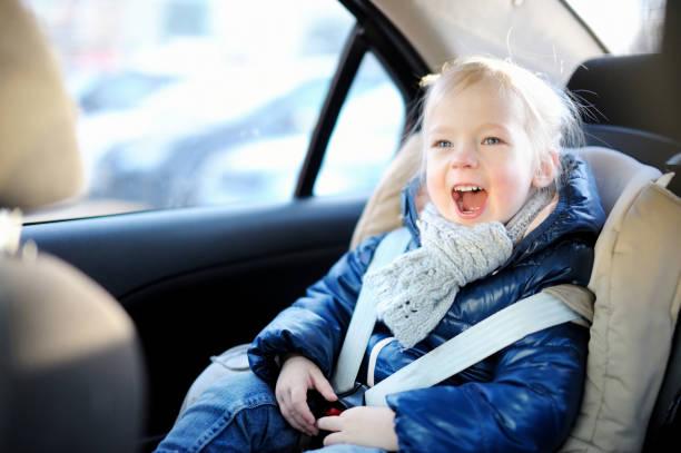 adorable little girl sitting in a car seat - car baby baby car seat child imagens e fotografias de stock