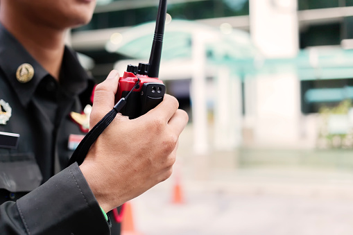 El guardia de seguridad utiliza la comunicación por radio para facilitar el tráfico. Los oficiales de tráfico usan walkie talkie para mantener el orden en el estacionamiento en Tailandia. photo
