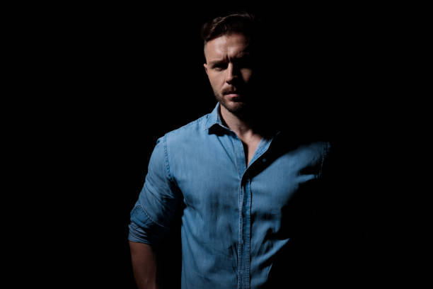 istock casual mysterious  man standing in the shadows 1181040974