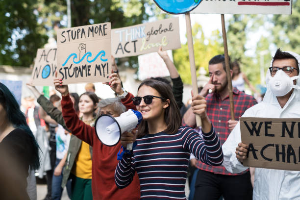 istock People with placards and amplifier on global strike for climate change. 1181042124
