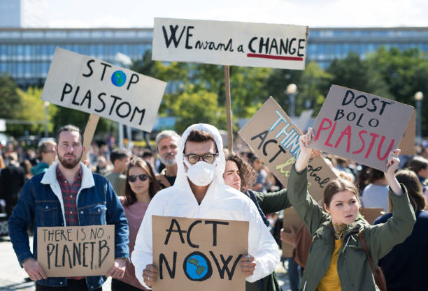 istock People with placards and protective suit on global strike for climate change. 1181042441