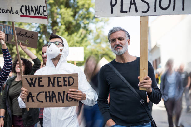 istock People with placards and protective suit on global strike for climate change. 1181042454