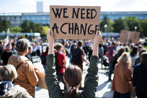 rear view of people with placards and posters on global strike for climate change. - protesto imagens e fotografias de stock