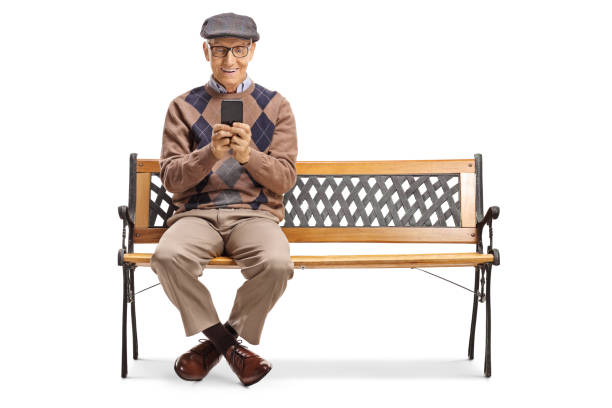 istock Elderly gentleman sitting on a bench and using a mobile phone 1181047542