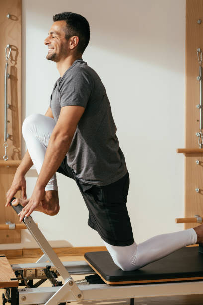 istock Sportsman Doing Reformer Pilates Exercise 1181054776