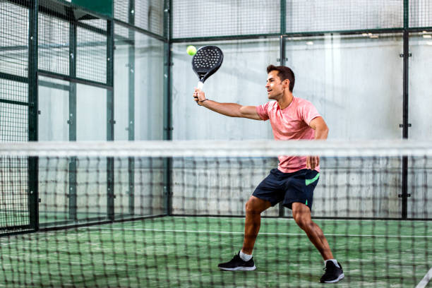 man playing padel - tennis indoors court ball imagens e fotografias de stock