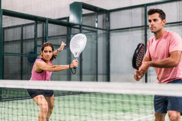 смешанные падель матч в падель суд в помещении - tennis court indoors net стоковые фото и изображения