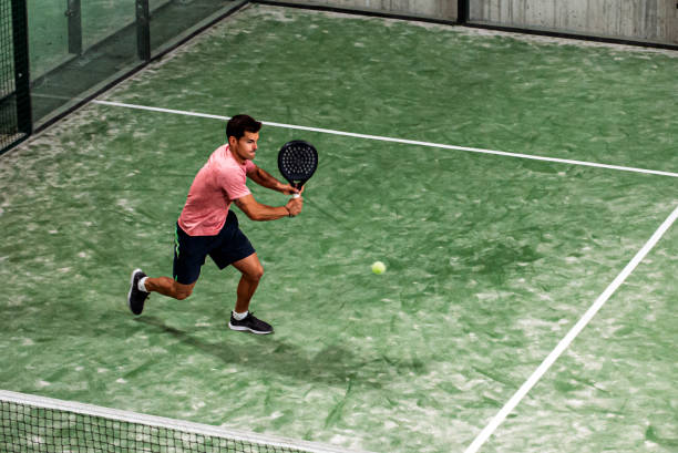 hombre jugando al pádel - racket ball indoors competition fotografías e imágenes de stock