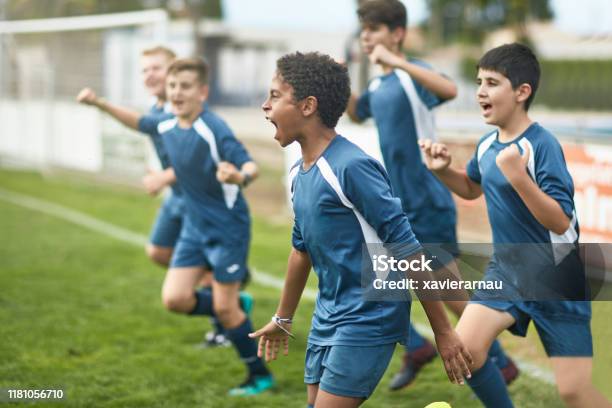 Team Von Selbstbewussten Jungen Männlichen Fußballern Läuft Auf Dem Feld Stockfoto und mehr Bilder von Fußball
