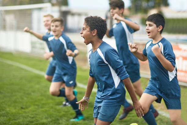 squadra di giovani calciatori uomini fiduciosi che corrono sul campo - child playing running group of people foto e immagini stock