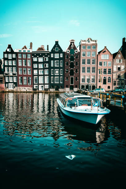 boat moored in amstel river canal, the netherlands - amstel river amsterdam architecture bridge imagens e fotografias de stock