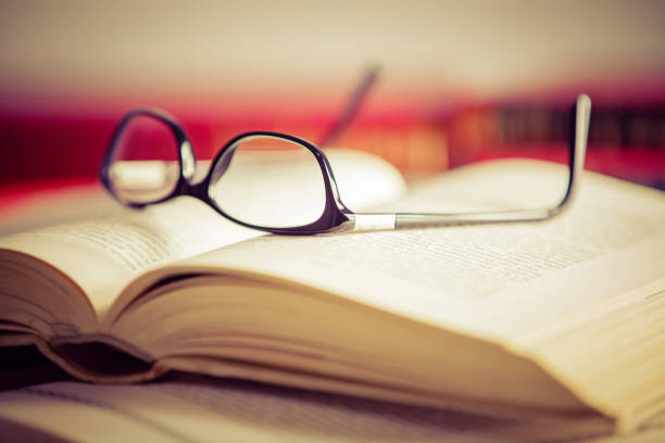 istock Glasses lies on red books 1181062582