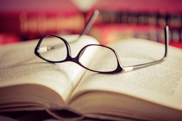 istock Glasses lies on red books 1181062712