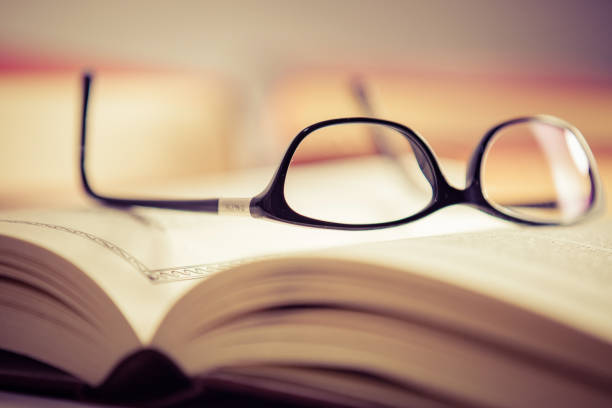 istock Glasses lies on red books 1181062773