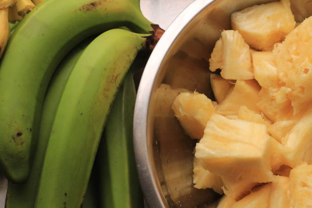 istock Green Bananas and Yellow Pineapples 1181062938