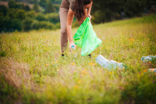 istock Female volunteer picks up trash in park 1181065484