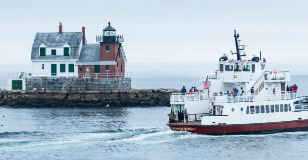 bateau de ferry passant le phare de briseurs de roche dans le maine - travel maine coast region lighthouse lighting equipment photos et images de collection