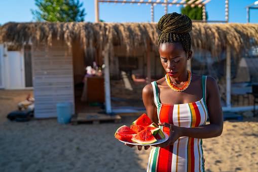 Portrait of African woman holding a plate with juicy watermelon