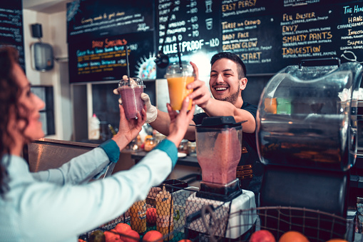 Female Picking Her Smoothies From Smiling Bartender