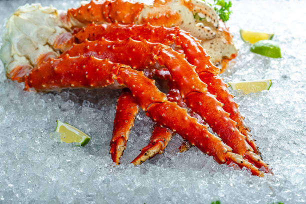 large red Kamchatka crab claws phalanx legs tentacles, lies on ice, cherry, slices of lemon and lime are sliced round, lie around, with fresh herbs, light, top side view, around grandes patas de cangrejo kamchatka rojo tentáculos de piernas, se encuentra en el hielo, cereza, rodajas de limón y lima se cortan en rodajas redondas, se encuentran alrededor, con hierbas frescas, luz, vista lateral superior, alrededor