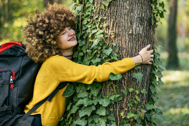 Nature Girl Young woman with long hair hugging tree in the forest hugging tree stock pictures, royalty-free photos & images